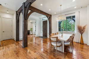 Dining area featuring recessed lighting, arched walkways, a chandelier, and wood finished floors