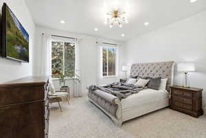 Bedroom featuring light colored carpet, a chandelier, and recessed lighting