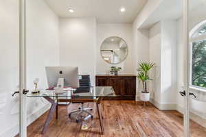 Office area with french doors, light wood-type flooring, and recessed lighting