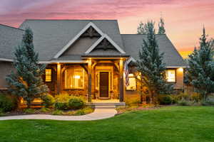 Craftsman inspired home with roof with shingles, a yard, and a porch