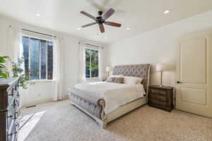 Bedroom with light colored carpet, recessed lighting, and a ceiling fan