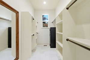 Walk in closet with light tile patterned floors