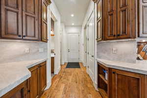 Kitchen with decorative backsplash, light wood-type flooring, light countertops, and recessed lighting