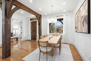 Dining room with light wood-style floors, recessed lighting, a chandelier, and arched walkways