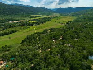 Aerial view of property's location with a mountain backdrop and property parcel outlined