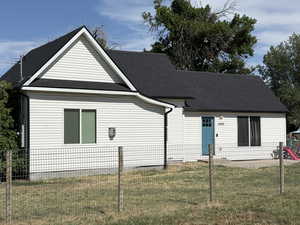 Back of property featuring roof with shingles and a fenced backyard