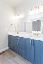 Full bath with double vanity and wood finished floors