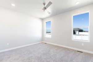 Carpeted spare room featuring a ceiling fan and recessed lighting