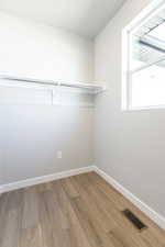 Walk in closet featuring wood finished floors