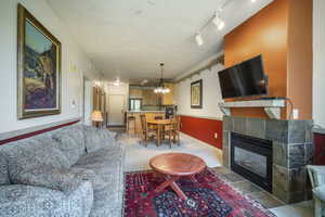 Living room with light colored carpet, a chandelier, and a fireplace