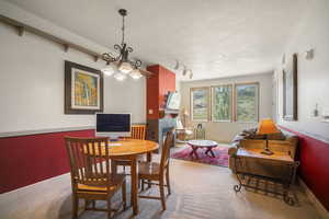 Carpeted dining space featuring a chandelier and baseboards