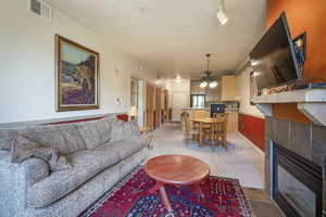 Living room featuring a tile fireplace, a chandelier, and light colored carpet