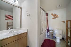 Bathroom featuring vanity, bath / shower combo with glass door, and tile patterned floors