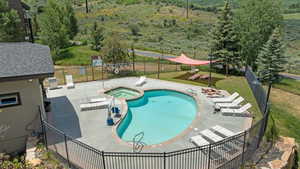 View of pool with a patio area and a pool with connected hot tub
