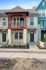 Multi unit property featuring a balcony, stucco siding, roof with shingles, and stone siding