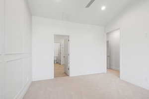 Unfurnished bedroom with light carpet, recessed lighting, connected bathroom, and ceiling fan