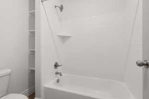 Bathroom featuring toilet and bathtub / shower combination