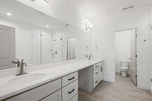 Full bath featuring double vanity, a shower stall, and recessed lighting