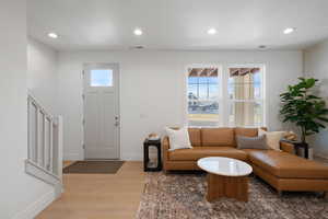 Entryway with light wood finished floors, healthy amount of natural light, and recessed lighting
