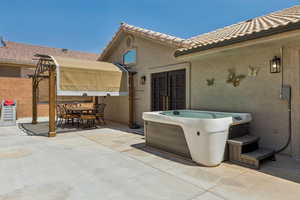 View of patio / terrace featuring a hot tub and outdoor dining area