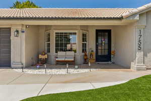 Entrance to property featuring stucco siding and a tile roof