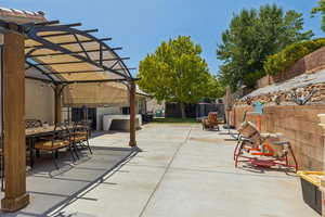 Fenced backyard featuring a pergola, outdoor dining area, and a patio