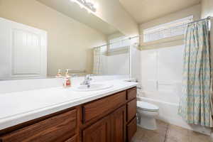Full bath featuring vanity, shower / bath combo with shower curtain, and tile patterned floors
