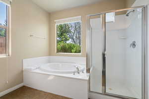 Full bath featuring a stall shower, plenty of natural light, a garden tub, and tile patterned floors