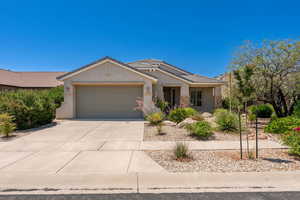 Ranch-style home featuring a garage, stucco siding, driveway, a tiled roof, and stone siding