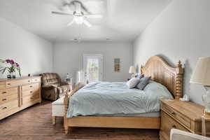 Bedroom with access to exterior, dark wood finished floors, and a ceiling fan