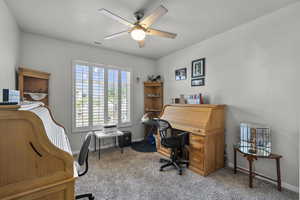 Office with a ceiling fan and carpet