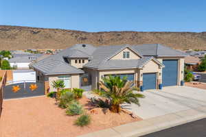 View of front of house with a gate, stucco siding, driveway, a garage, and a mountain view