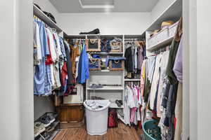 Walk in closet with attic access and wood finished floors