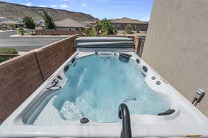 View of pool featuring a hot tub, a pool, a mountain view, and a residential view