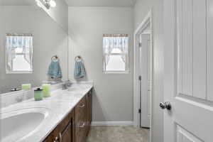 Bathroom with double vanity and baseboards