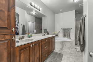 Full bath with a garden tub, double vanity, and a closet