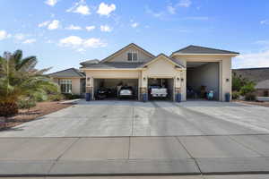 View of front of home featuring concrete driveway, a garage, stucco siding, and stone siding