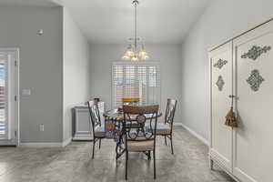 Dining area featuring a chandelier and baseboards