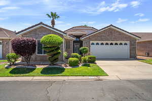 Ranch-style house with brick siding, a tiled roof, concrete driveway, and a garage