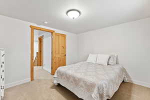 Bedroom with light colored carpet and baseboards