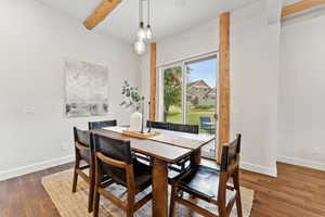Dining room with wood finished floors and beamed ceiling