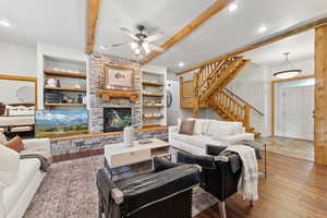 Living area featuring stairway, ceiling fan, beamed ceiling, built in features, and recessed lighting