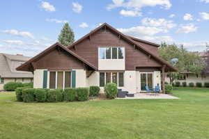 Back of property with a patio, stucco siding, and a lawn