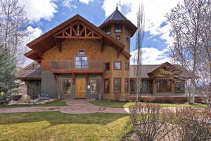 View of front of house with a balcony and a front yard
