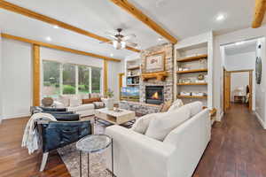 Living room with a ceiling fan, beam ceiling, dark wood finished floors, a fireplace, and recessed lighting