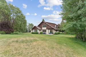 Back of property with a lawn, a patio area, and stucco siding