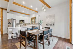 Dining area featuring beam ceiling, recessed lighting, and dark wood-style flooring