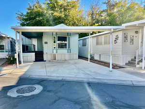 Manufactured / mobile home featuring covered porch and a carport