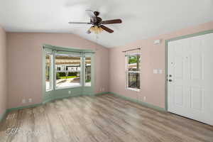 Entrance foyer with wood finished floors, vaulted ceiling, and ceiling fan