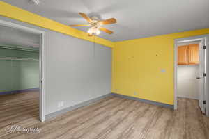 Unfurnished bedroom with light wood finished floors, a ceiling fan, and a textured ceiling